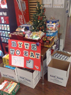 Table with Byte to Eat poster, donations, and Christmas tree