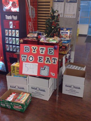 Table with Byte to Eat poster, donations, and Christmas tree
